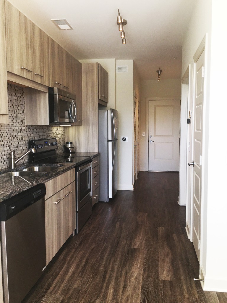 The beautiful, contemporary kitchen is outfitted with all-new stainless steel appliances, designer cabinetry, a glass-tile backsplash and granite countertops. Beside her fridge is a Nest thermostat which intuitively learns her climate control preferences.